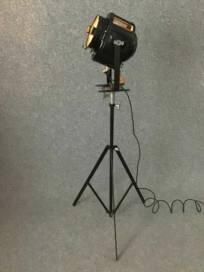 Großer schwarzer Studioscheinwerfer auf einem Metallstativ mit Kabel, perfektioniert für den Einsatz in Film- und Fotostudios