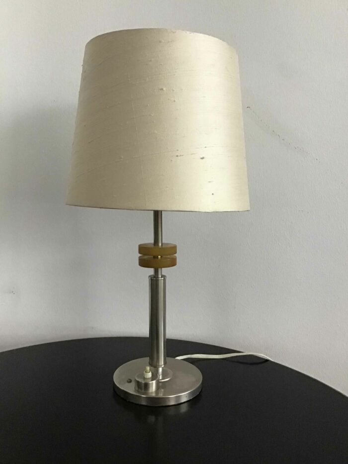 Schlichtes und modernes Design einer Tischlampe mit einem hellen Stoffschirm und Metallelementen, ideal für minimalistisches Interieur