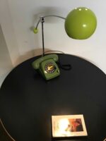 Retro-Kombination aus grünem Wählscheibentelefon mit integrierter Schreibtischlampe. Eine nostalgische Ergänzung für jede Einrichtung mit einem Hauch von Retro