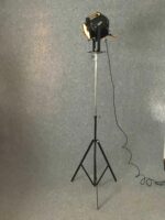 Vollständige Ansicht eines Studioscheinwerfers auf hohem Stativ mit Kabel