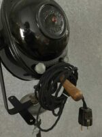 Rückansicht eines Studioscheinwerfers mit aufgewickeltem Kabel und Holzgriff, betont die stabile Konstruktion und Funktionalität