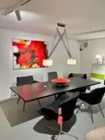 Dynamisches abstraktes Kunstwerk mit dominierenden roten und schwarzen Farbtönen, kombiniert mit sanften Beige- und Weißakzenten. Die kräftigen Farben und fließenden Formen erzeugen eine energiegeladene, expressive Atmosphäre. Perfekt für moderne Wohnräume oder Galerien.